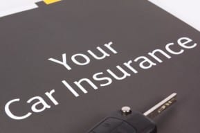 Keys on top of a car insurance document