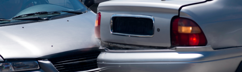 a car crashed into another car while getting out of a parking lot